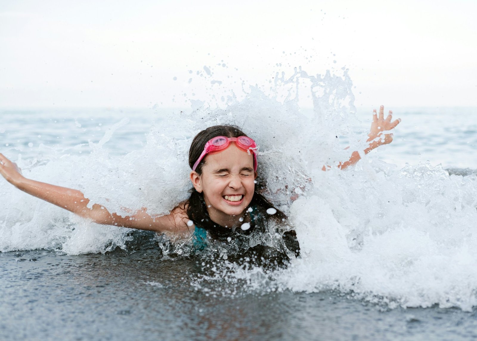 a young girl is playing in the water